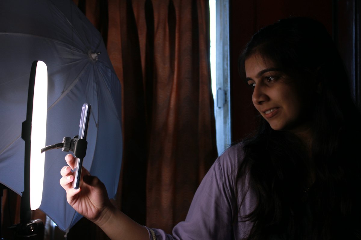 Woman filming a video on a phone with a ring light